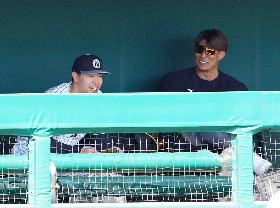 　ベンチで糸井ＳＡ（右）と談笑する佐藤輝（撮影・立川洋一郎）