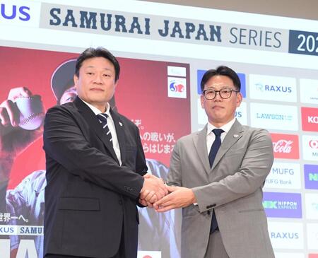 　ＮＰＢの中村事務局長（左）と握手をする井端監督（撮影・園田高夫）