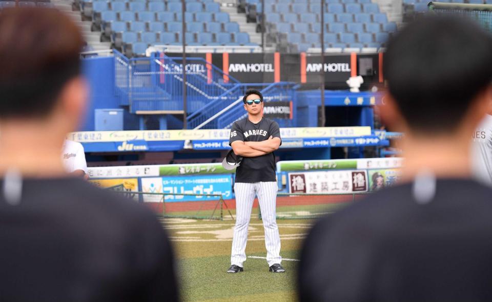 　練習前のミーティングでナインに無言のメッセージを送るサブロー新監督（中央）（撮影・開出牧）