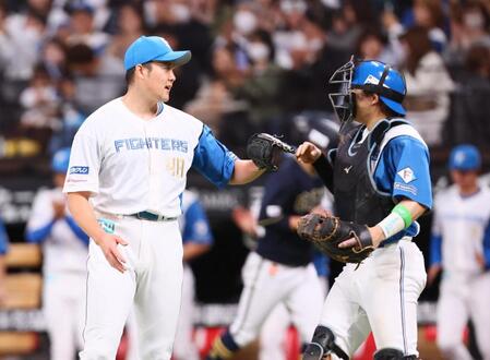 　９回を締め、田宮（右）とタッチを交わす斎藤（撮影・中島達哉）