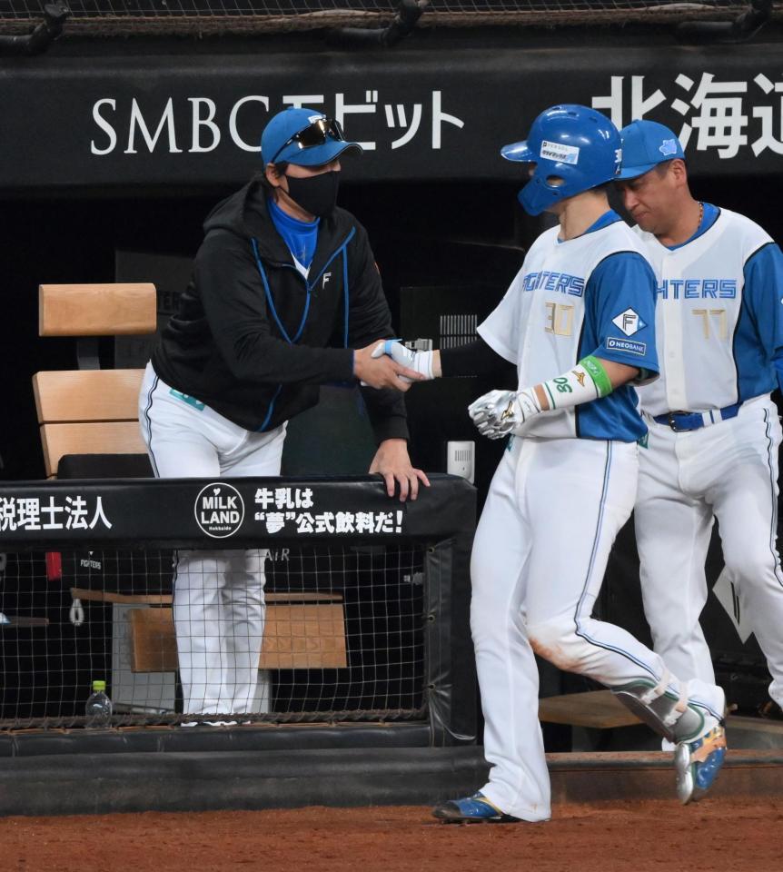 　４回、左越えソロを放った郡司（右）と握手で迎える新庄監督（撮影・伊藤笙子）