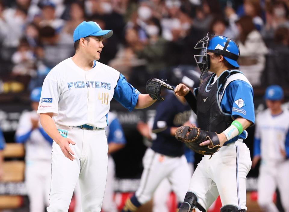 　９回を締め、田宮（右）とタッチを交わす斎藤（撮影・中島達哉）