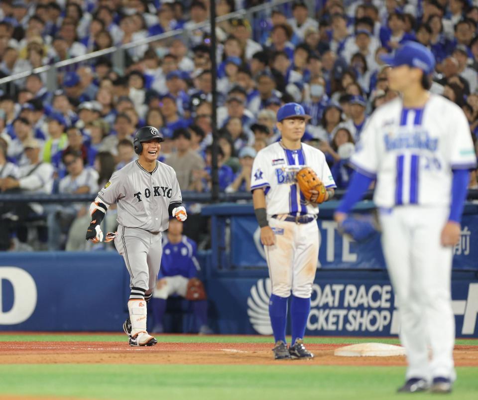 　１１回、内野安打で勝ち越しに成功し、笑顔を見せる佐々木（撮影・西岡正）