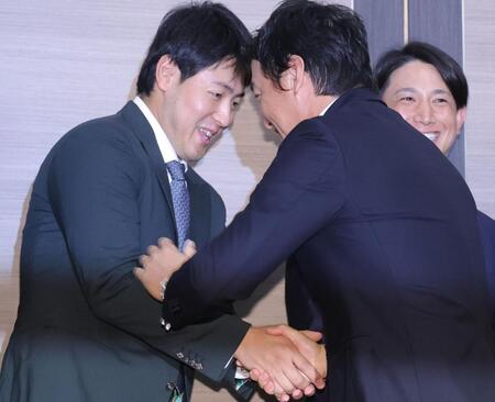 　岡本（左）と握手する長野（撮影・西岡正）