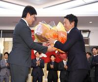 　岡本（左）から花束を受け取る長野（撮影・西岡正）