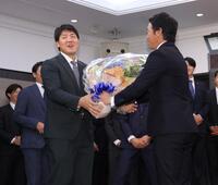 　長野（右）から花束を渡されて困惑する岡本（撮影・西岡正）