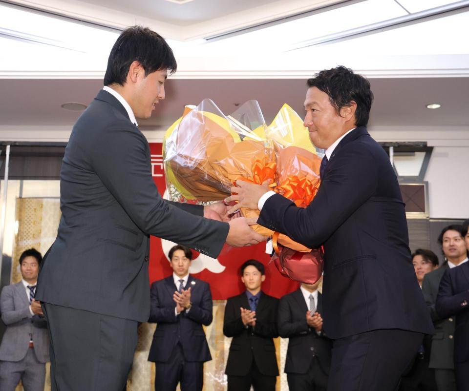 　岡本（左）から花束を受け取る長野（撮影・西岡正）