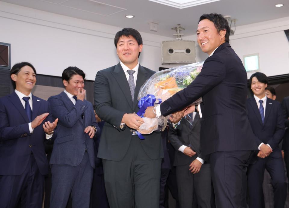 　岡本（手前左）に花束を渡す長野（撮影・西岡正）