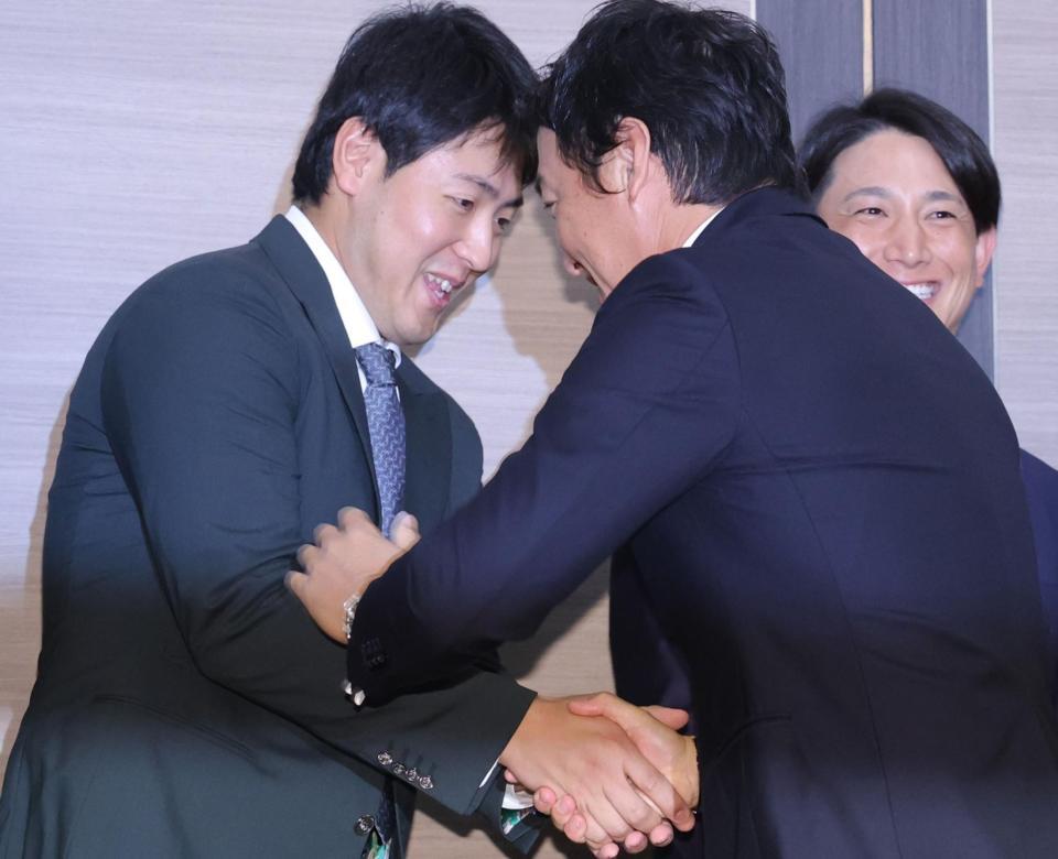 　岡本（左）と握手する長野（撮影・西岡正）