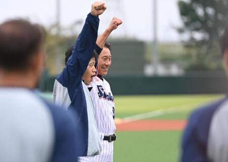 　練習前のミーティングで塩見（手前）と共にガッツポーズを決める池山新監督（撮影・開出牧）