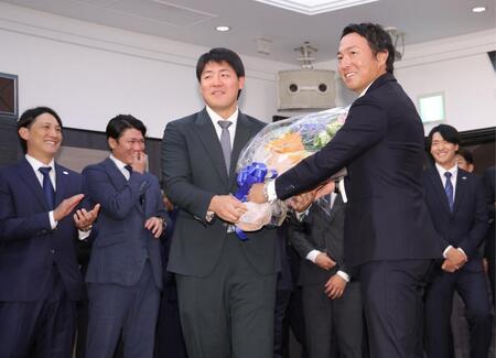 　岡本（手前左）に花束を渡す長野（撮影・西岡正）