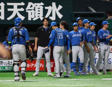 　１０回、山川にサヨナラ打を許し、ベンチに下がる玉井（中央）を迎える日本ハムナイン（撮影・中島達哉）