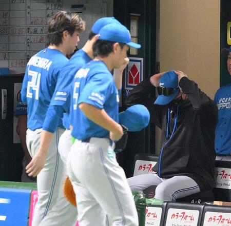 　１０回、絶体絶命のピンチを作った金村（手前左）を交代させ、頭を抱える新庄監督（撮影・伊藤笙子）