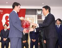 　坂本（左）から花束を受け取る長野（撮影・西岡正）