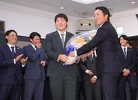 　岡本（手前左）に花束を渡す長野（撮影・西岡正）