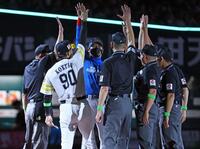 　メンバー表を交換し、小久保監督（９０）、審判団と手を挙げる新庄監督（中央）＝撮影・中島達哉