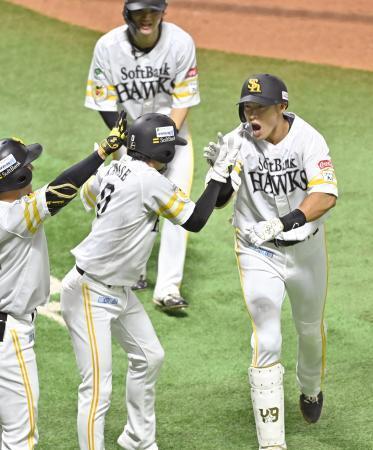 　８回、決勝の３ランを放ちナインに迎えられるソフトバンク・柳田（右端）＝みずほペイペイドーム