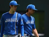 　８回途中で降板し、福島（左）に迎えられる上原（撮影・中島達哉）