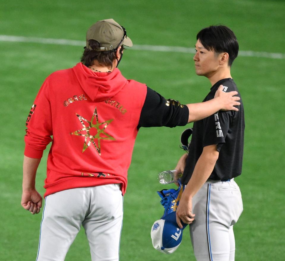 　試合前、新庄監督（左）に話しかけられる玉井（撮影・伊藤笙子）