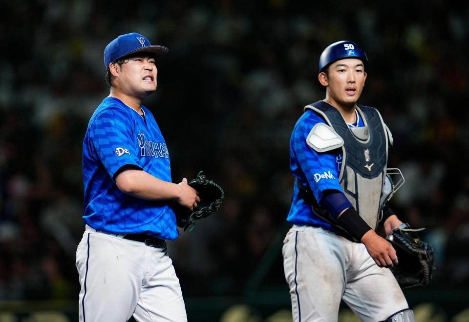　８回、阪神に同点を許し、ベンチへ戻る伊勢（左）と山本のバッテリー