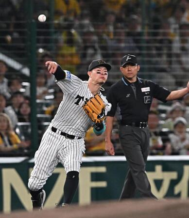 　１回、桑原の打球を一塁へ悪送球する佐藤輝（撮影・西田忠信）