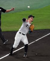 　１回、佐藤輝は桑原のゴロを捕球し一塁への送球が悪送球になる（撮影・山口登）