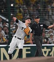 　１回、桑原の打球を一塁へ悪送球する佐藤輝（撮影・西田忠信）