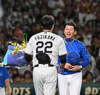 　今季限りで退任する三浦監督（右）は藤川監督からサプライズで花束を受け取る（撮影・西田忠信）