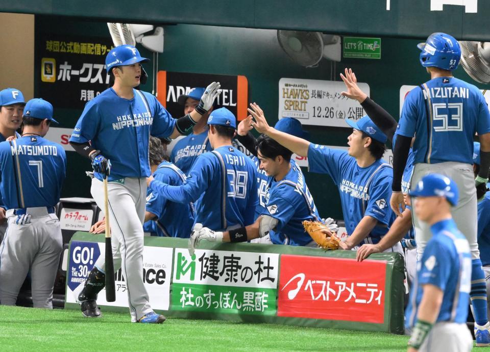 　１回、上沢から先制の右犠飛を放ち、ナインに迎えられる郡司（左）＝撮影・伊藤笙子