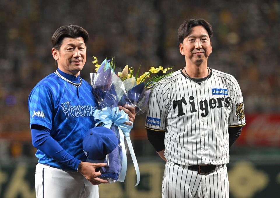 　藤川監督（右）から花束を贈られる三浦監督（撮影・飯室逸平）