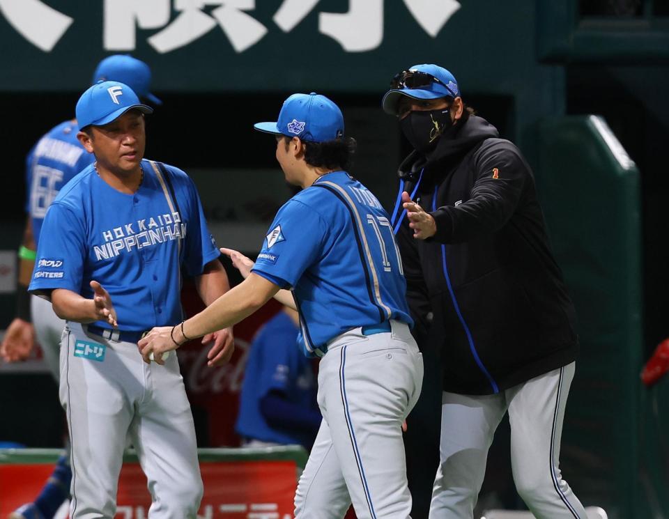 　伊藤（中央）を迎える新庄監督（右）＝撮影・中島達哉