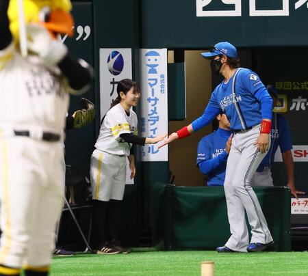 　試合前、ボールボーイ、ボールガールとタッチを交わす新庄監督（右）＝撮影・中島達哉