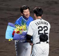 　三浦監督は藤川監督から花束を贈られ笑顔を見せる＝１７日