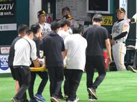 　３回、一ゴロに倒れた際に審判と交錯し担架で運ばれる中村（手前）を見つめる小久保監督（撮影・伊藤笙子）