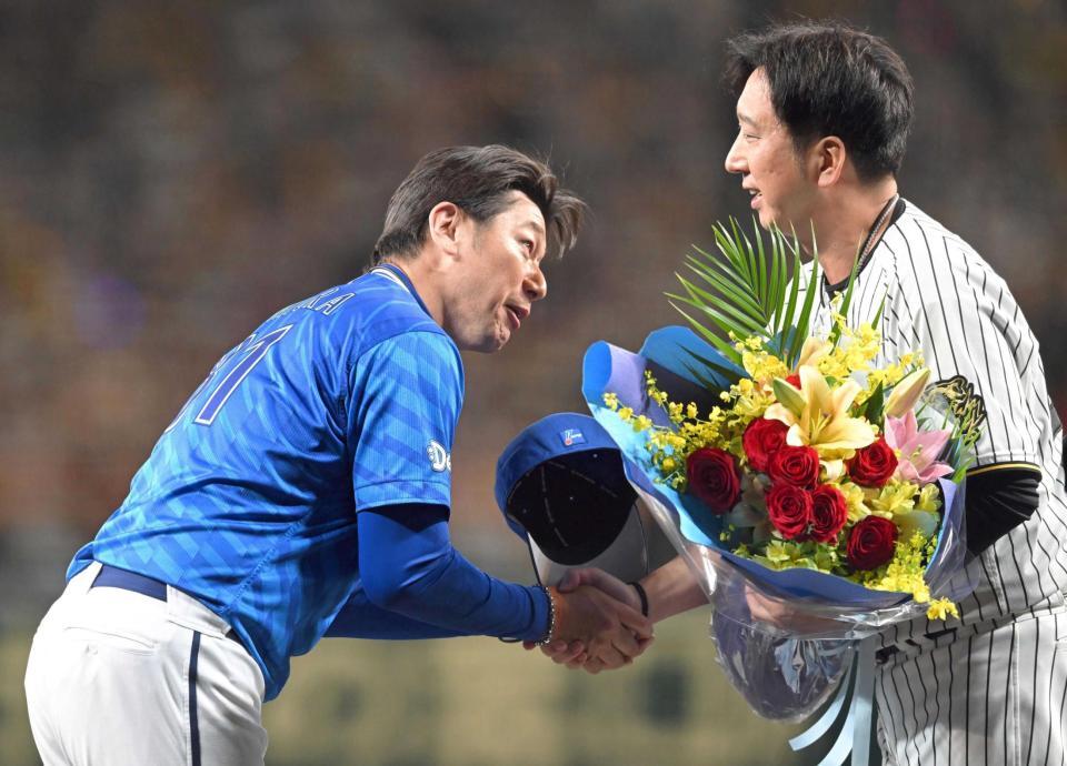 　試合後、藤川監督（右）から花束を贈られる三浦監督（撮影・飯室逸平）