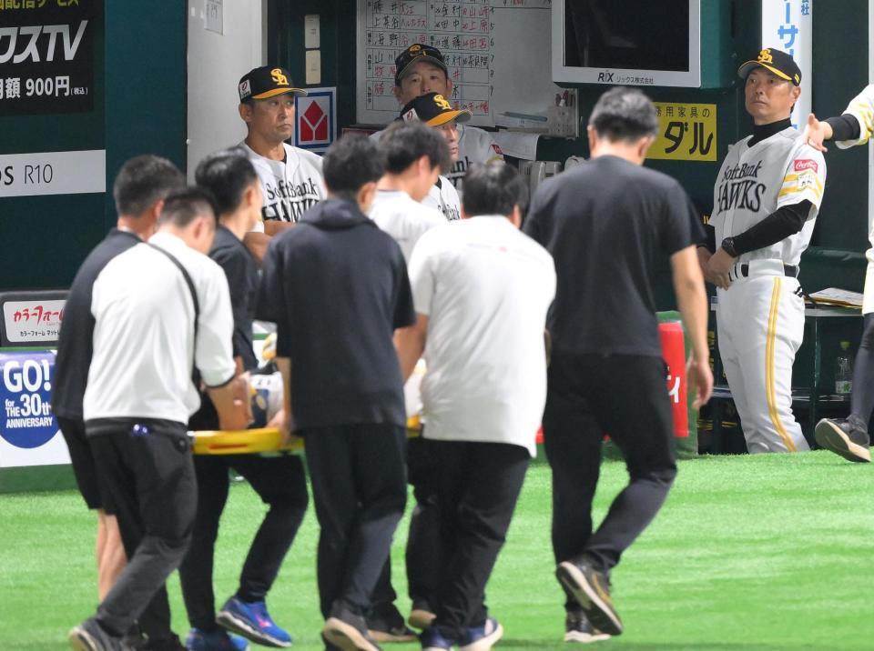 　３回、一ゴロに倒れた際に審判と交錯し担架で運ばれる中村（手前）を見つめる小久保監督（撮影・伊藤笙子）