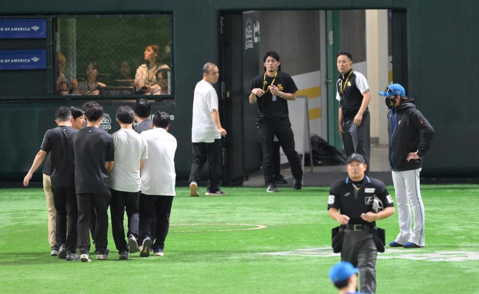 　１回、二盗した周東と交錯し担架で運ばれる山県を心配そうに見つめる新庄監督（右）＝撮影・伊藤笙子