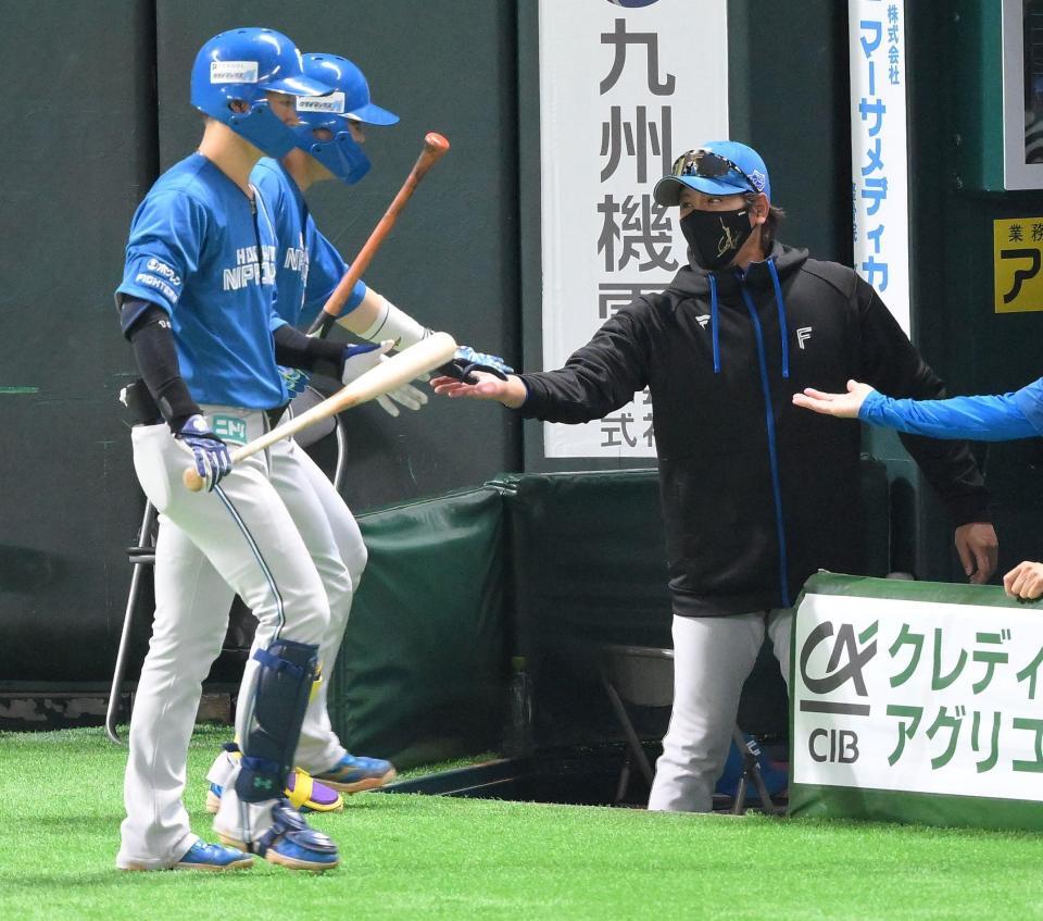 　５回、スクイズを決めた田宮（左奥）を迎える新庄監督（撮影・伊藤笙子）