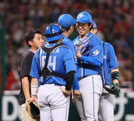 　５回途中で降板となり、加藤投手コーチ（中央）からねぎらわれる古林（同右）＝撮影・中島達