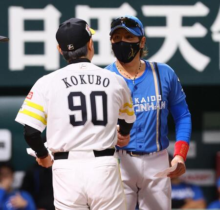 　メンバー表を交換し、小久保監督（９０）と握手を交わす新庄監督（撮影・中島達哉）