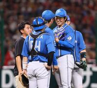 　５回途中で降板となり、加藤投手コーチ（中央）からねぎらわれる古林（同右）＝撮影・中島達