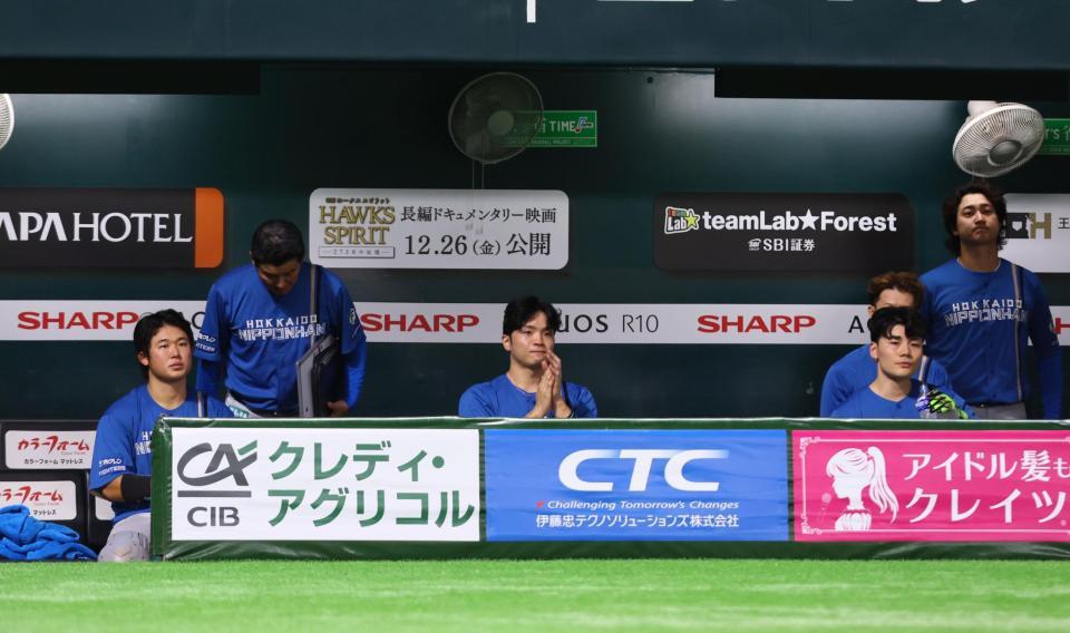 　歓喜するソフトバンクナインに拍手を送る郡司（中央）ら日本ハムナイン（撮影・中島達哉）