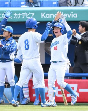 　７回、相手の失策間に２点を先制し、生還した三走・初谷健心（左）を迎える青学大・小田康一郎（撮影・伊藤笙子）