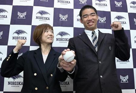 　オリックスから１位で指名され、笑顔で写真撮影する延岡学園・藤川敦也（右）と母親の七恵さん