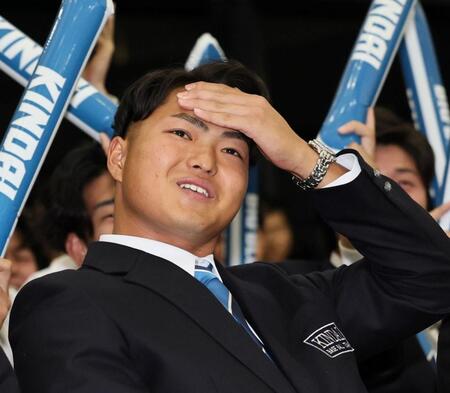 　楽天から７位指名を受け、ホッとした表情を浮かべる近大・阪上翔也（撮影・田中太一）