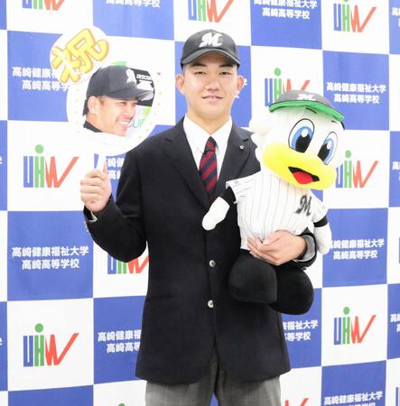 　ロッテから１位指名を受け「サブロー監督うちわ」を手に笑顔の健大高崎・石垣