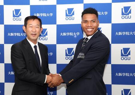 　中村良二監督（左）と握手を交わす大院大のエドポロ・ケイン（撮影・中田匡峻）
