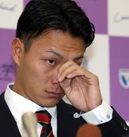 　楽天に１位指名された花園大・藤原聡大は会見で目頭を押さえる（撮影・山口登）