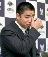 　オリックスからの１位で、涙を拭きながら記者会見する延岡学園・藤川敦也