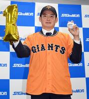 　巨人から１位指名を受け、ボールを手にポーズをとる鷺宮製作所・竹丸和幸